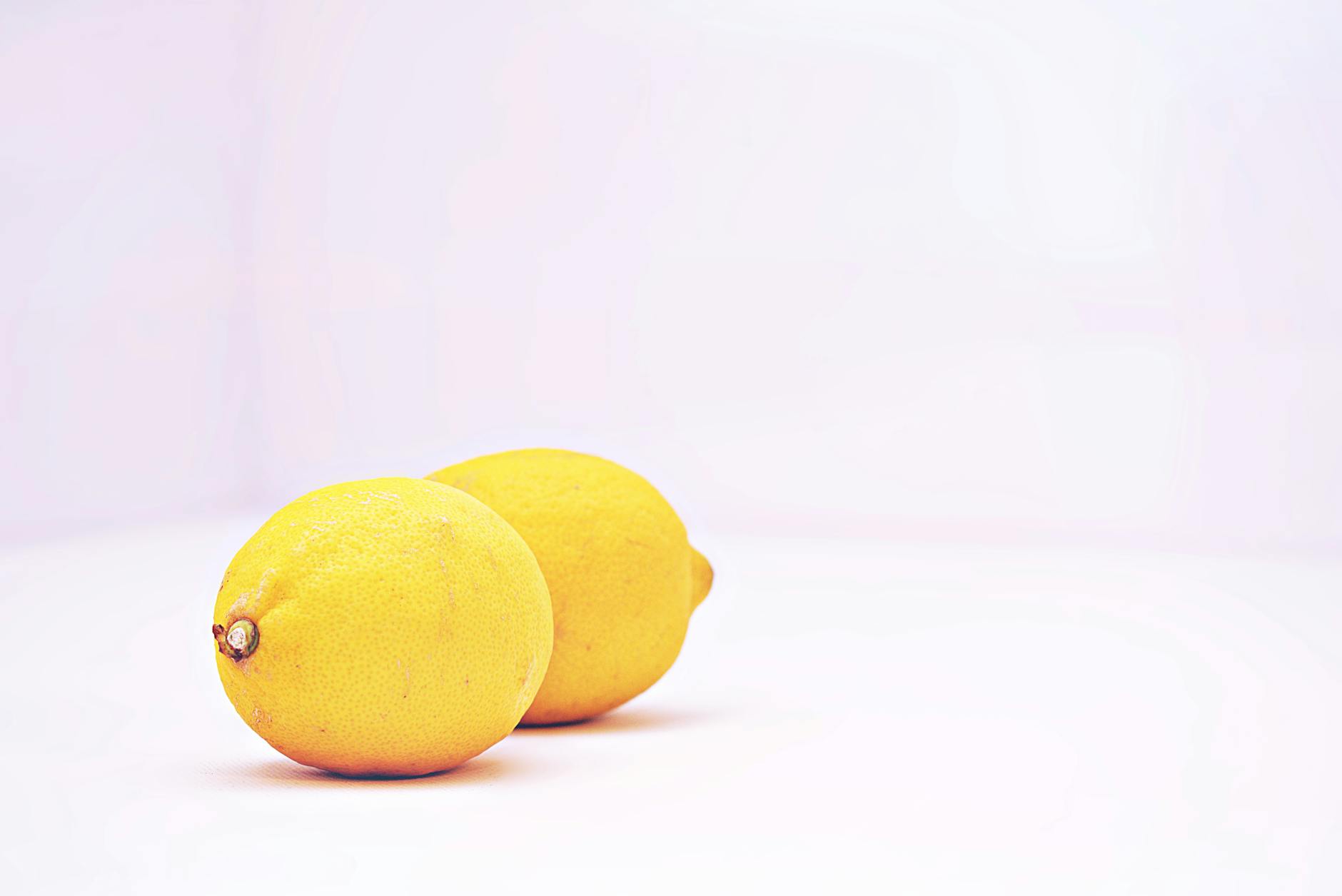 Vibrant blue suction vibrator surrounded by fresh fruit and flowers on bright yellow background