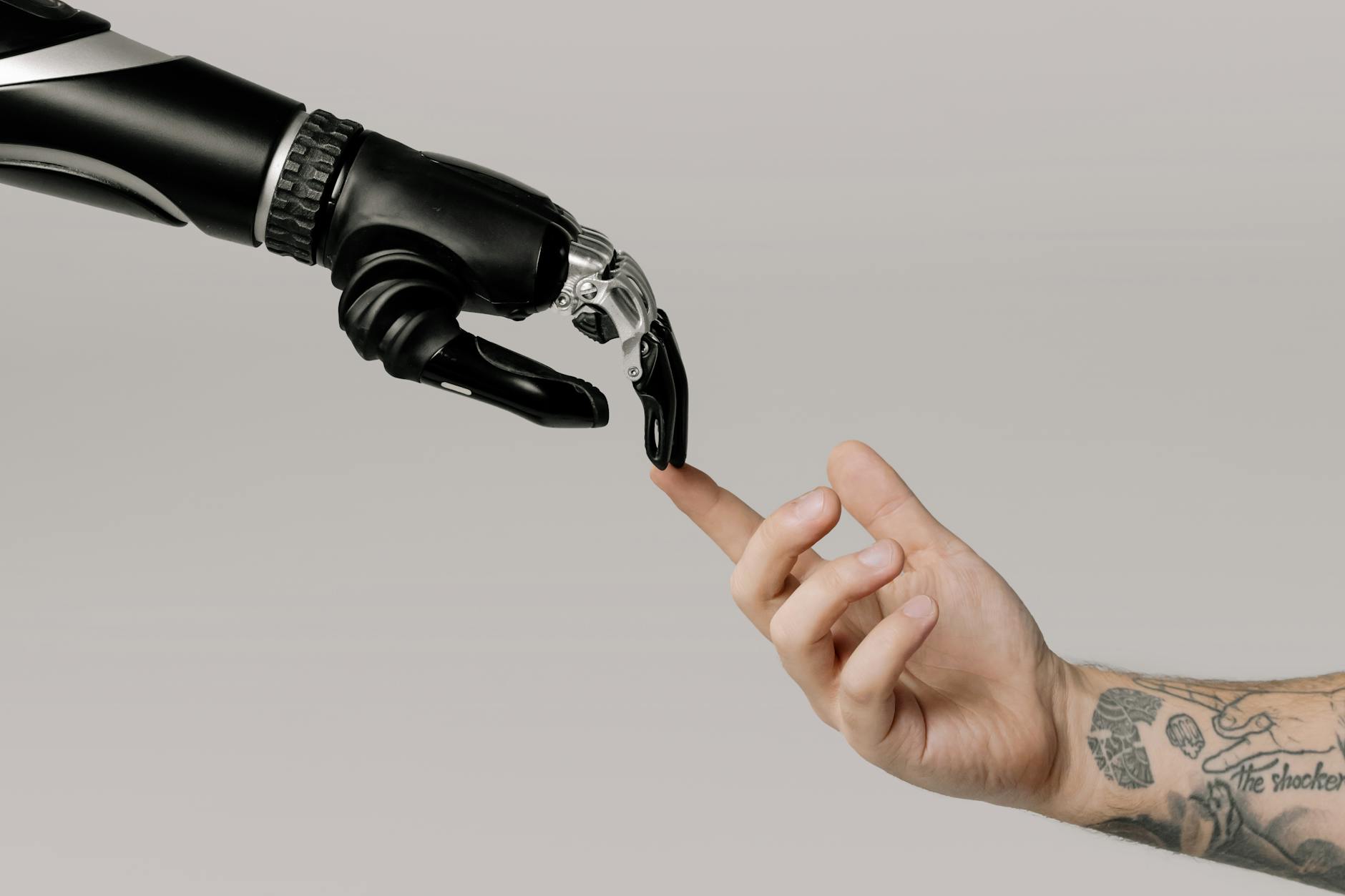 Two hands reaching toward each other, one with tattoos, symbolizing emotional connection and human touch.