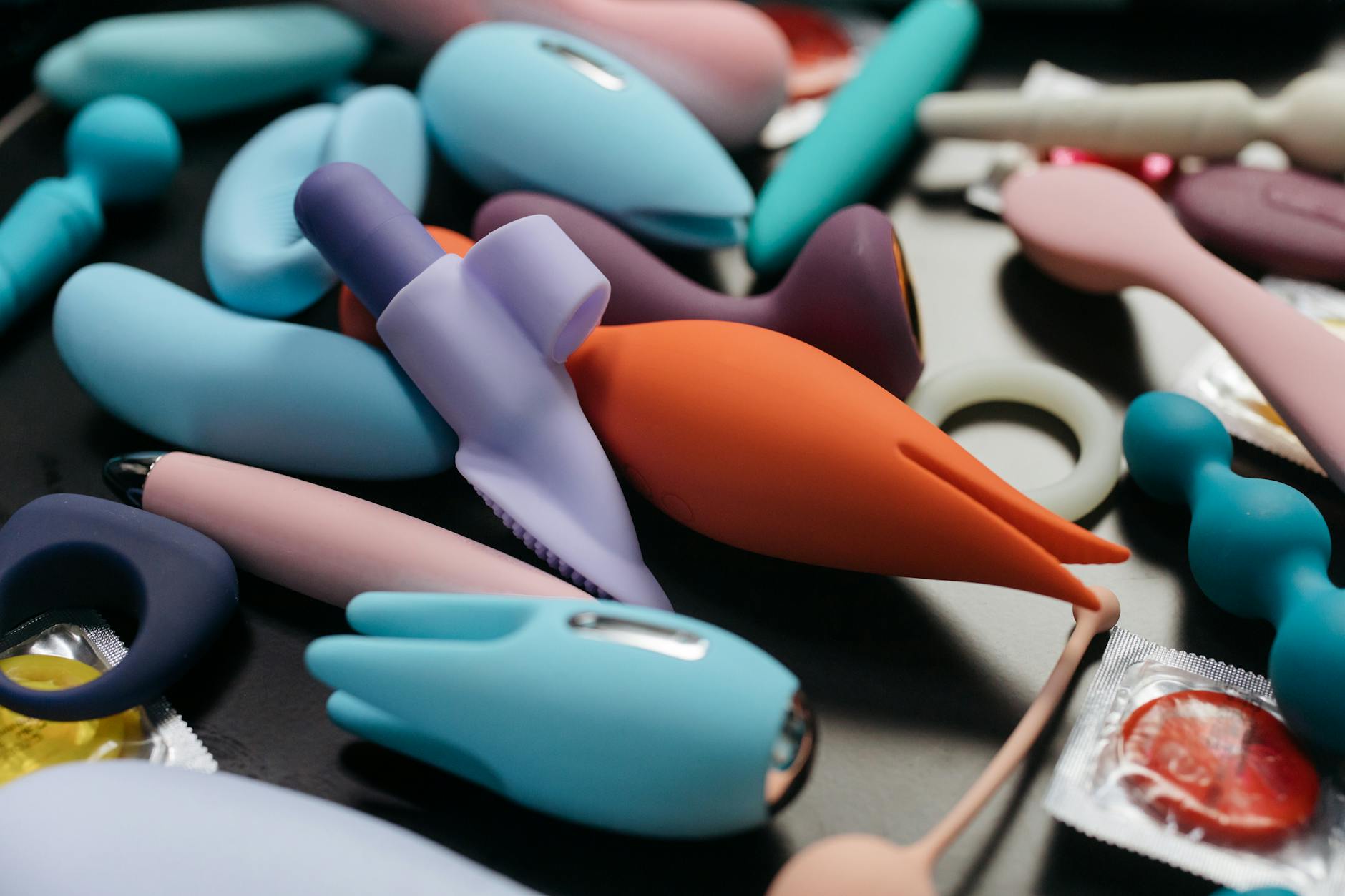 Woman holding colorful vibrators demonstrating pleasure tools during hormonal cycle