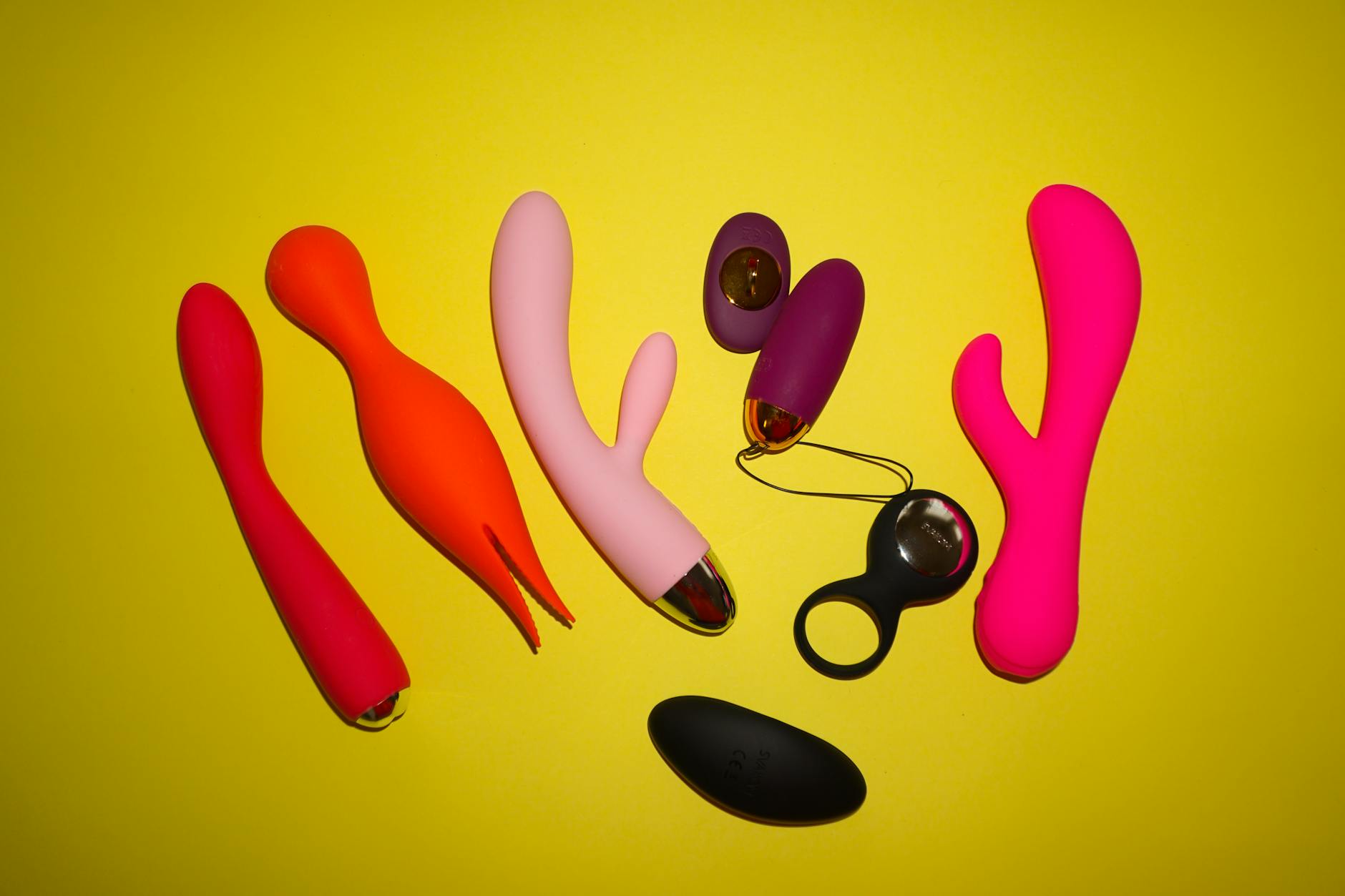 Close-up of a vibrator held in hand against a purple backdrop, showcasing modern sensuality